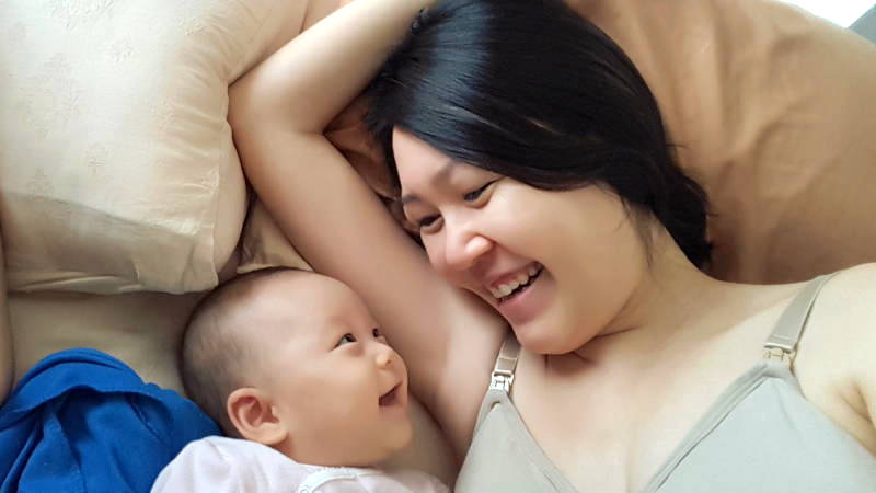 Buchup Month 4: With mama on the bed, smiling