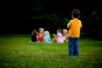 Lonely child looking at a group of children