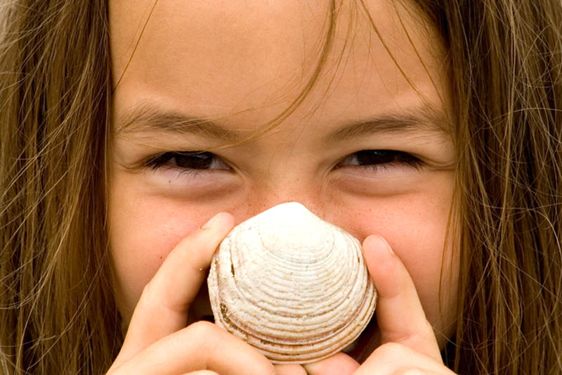 Girl smiling with a seashell