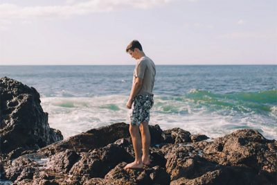 Guy standing on the rocks, by the sea
