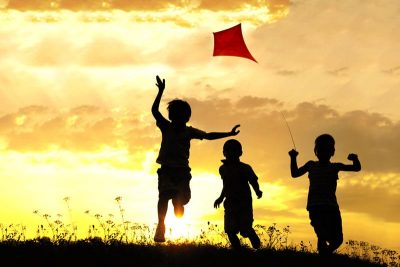 Children flying kite on a field