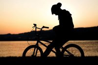 Silhouette of a person on a bicycle, grieving